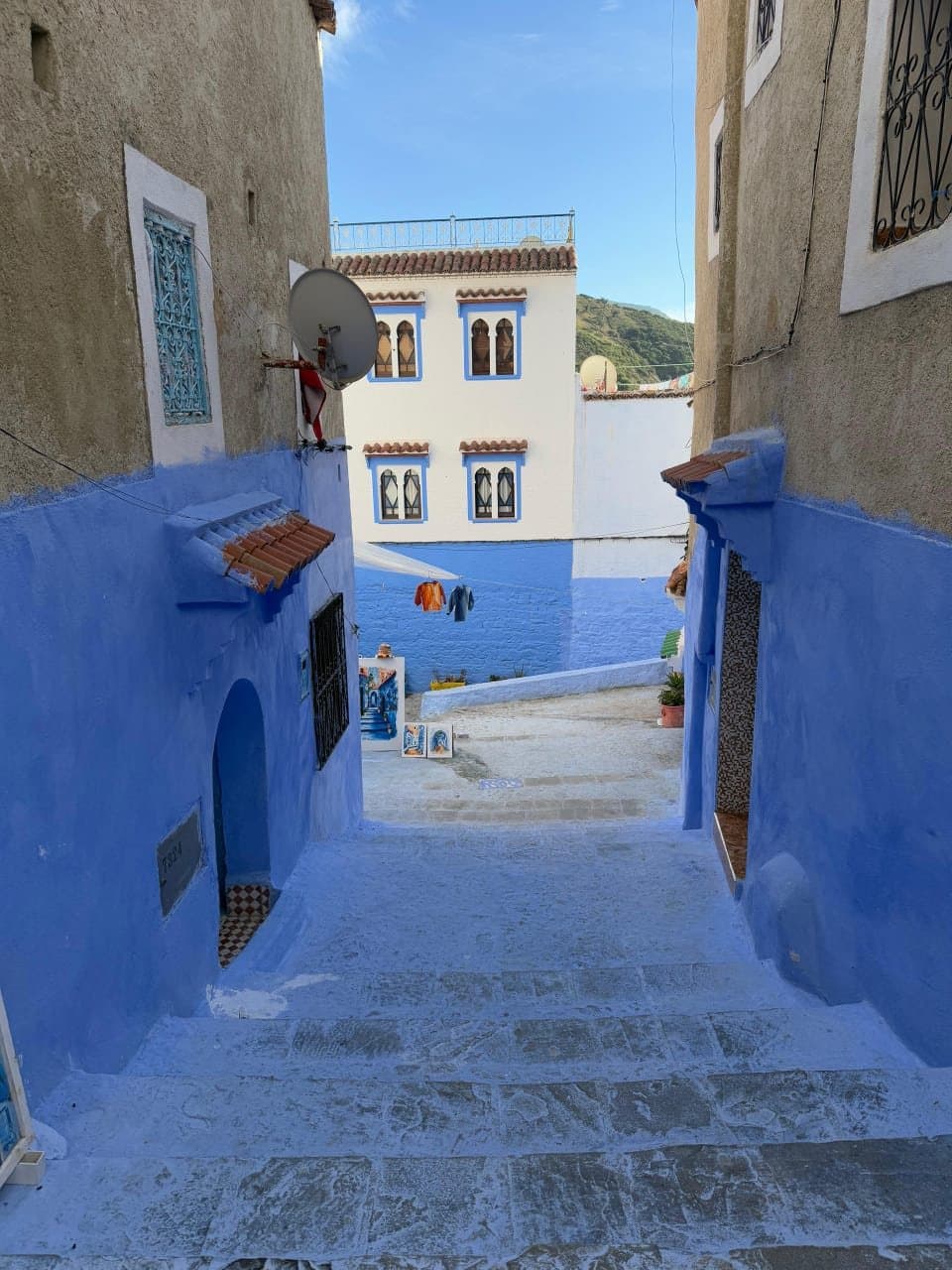 Een smalle blauwe steeg met traptreden in de medina van Chefchaouen
