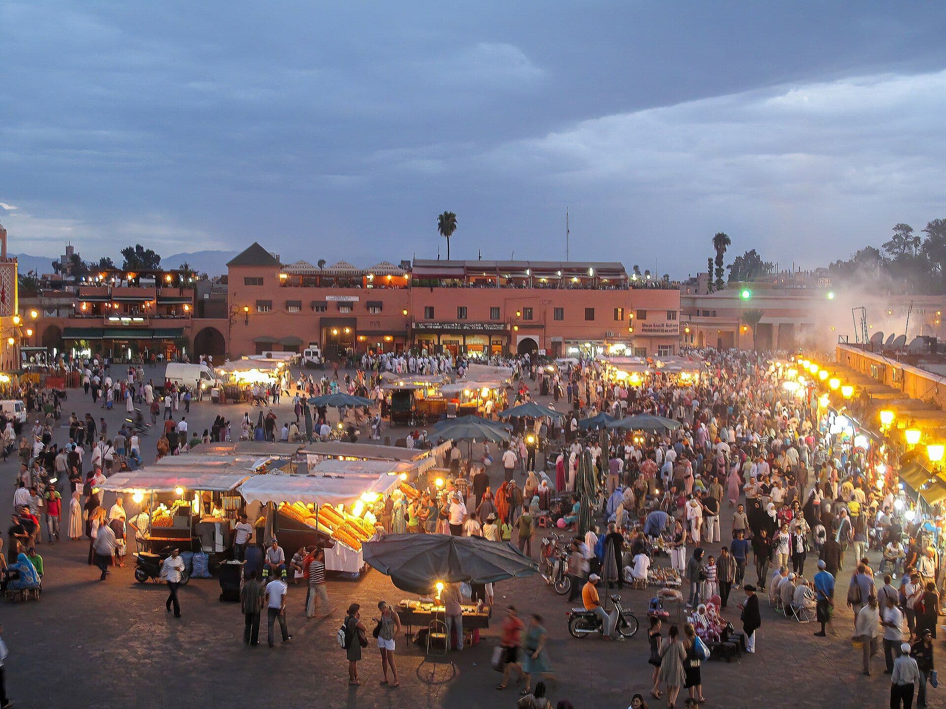 Jemaa el-Fna square in Marrakesh in the evening, with food stalls and the Koutoubia minaret in the background
