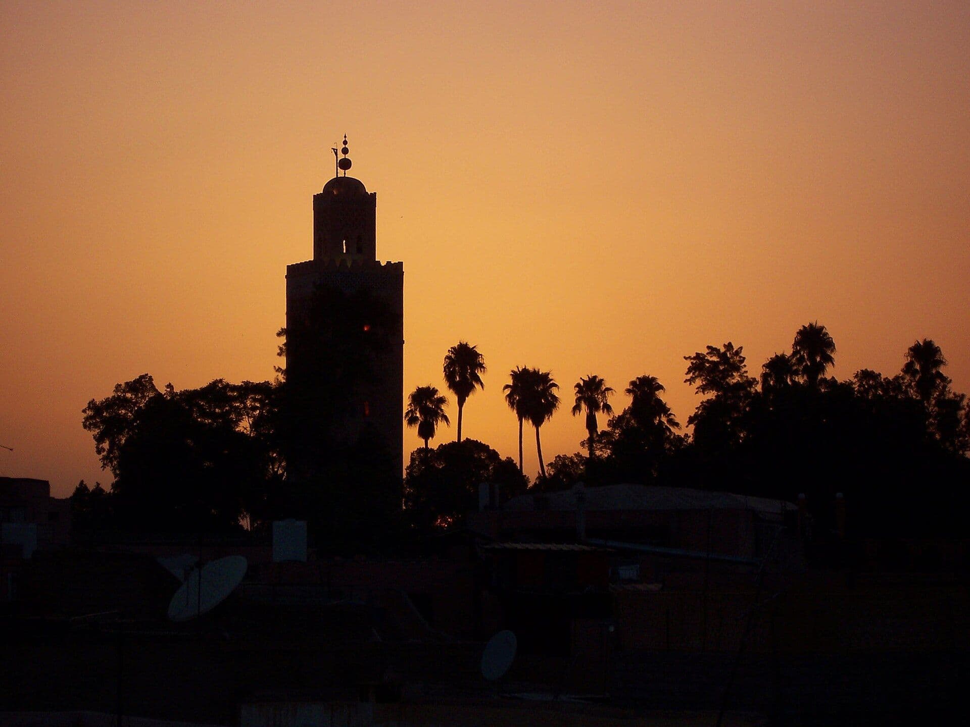 Silhouet van de Koutoubia-minaret in Marrakesh tegen een oranje avondlucht