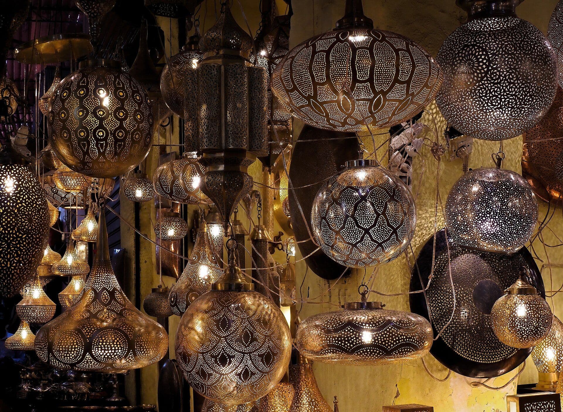 Koperen lantaarns met patronen hangen in een winkel in de souks van Marrakesh