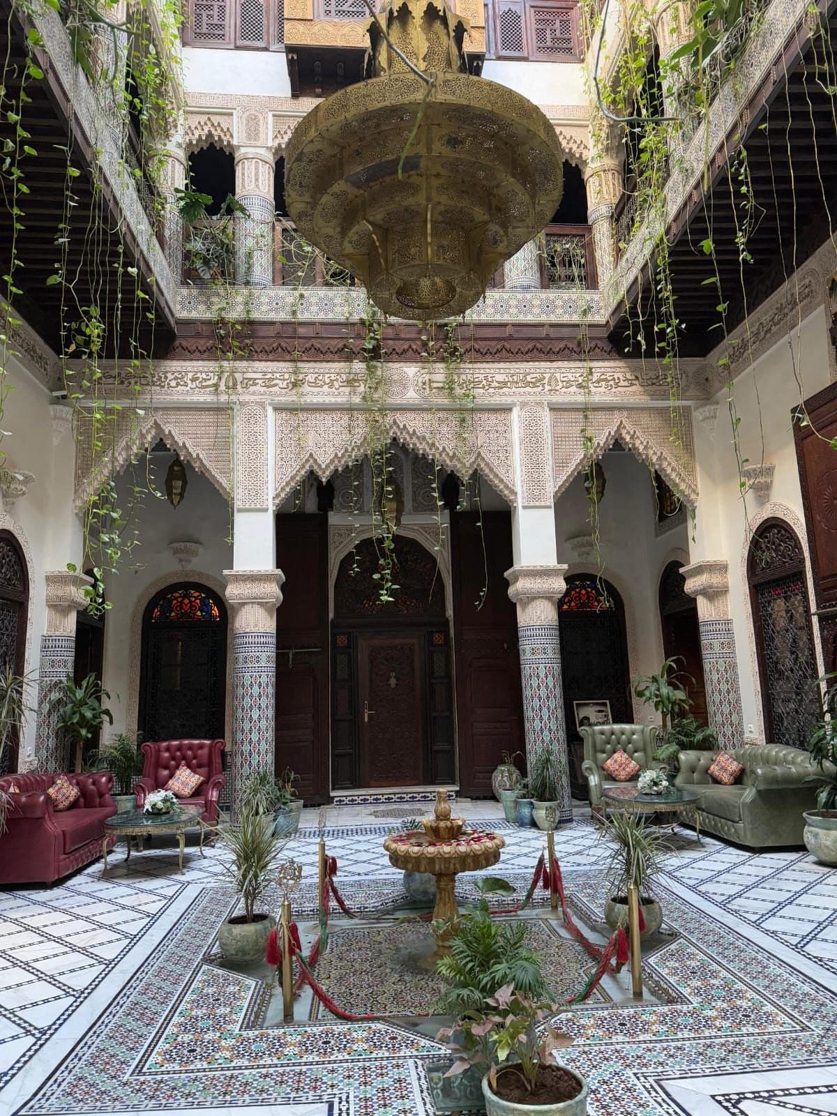 Courtyard of a riad with a fountain, zellige tiles and carved wood